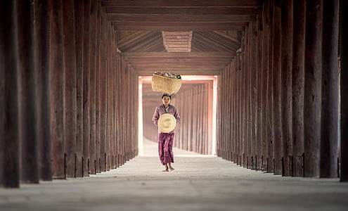woman carrying wicker basket while walking