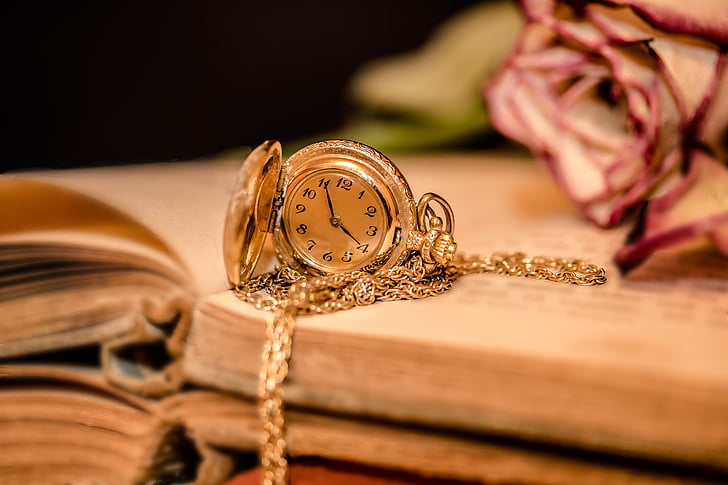 gold-colored analog pocket watch