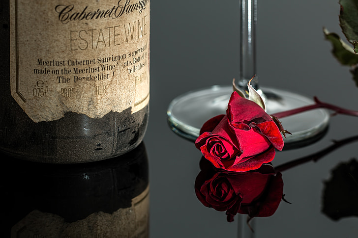 red rose near wine bottle photo