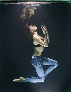 woman wears black brassiere and blue denim jeans underwater photo