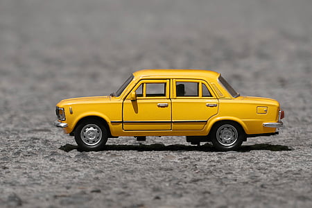 shallow focus photography of yellow taxi cab die-cast model