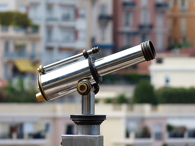 person taking photo of stainless steel coin generated telescope in tilt shift photography