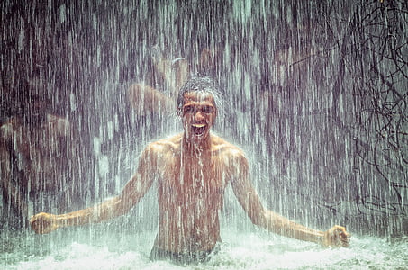 man under body of water during daytime