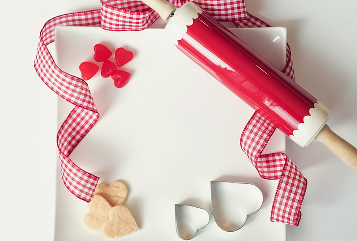 red and white rolling pin on white board
