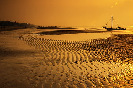 boat on sea near seashore during golden hour