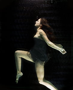 woman wears black tube dress underwater