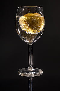 clear wine glass with liquid and brown apple