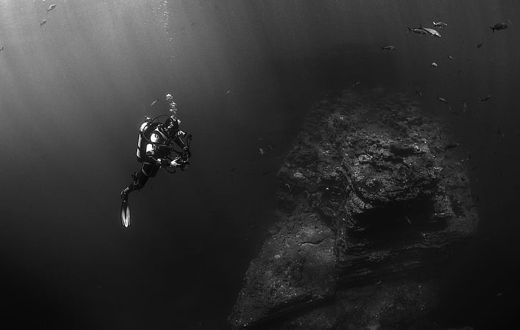 grayscale photography of man wearing diving suit