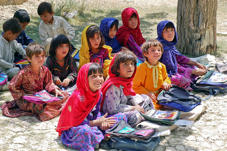 children sitting on ground during daytime