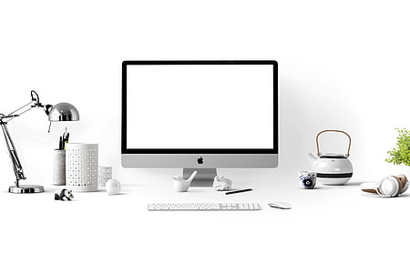 silver iMac beside wireless keyboard and mouse
