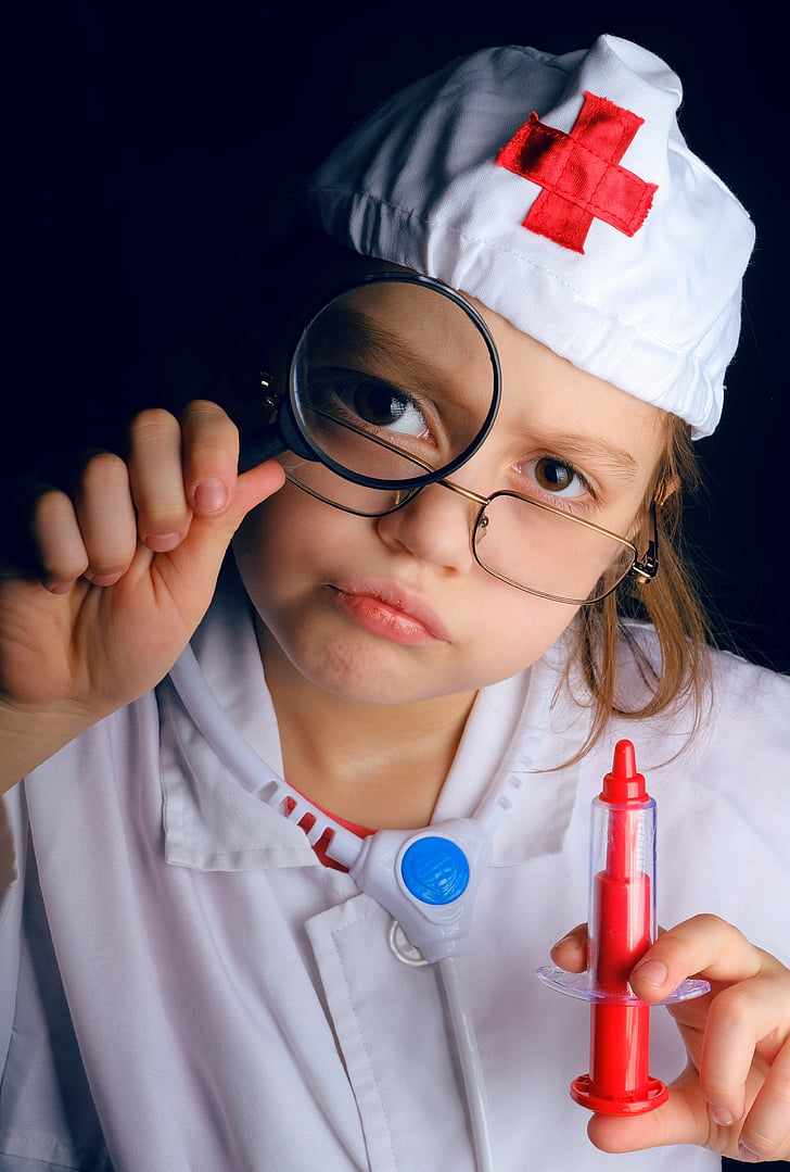 child wearing doctor costume holding syringe toy