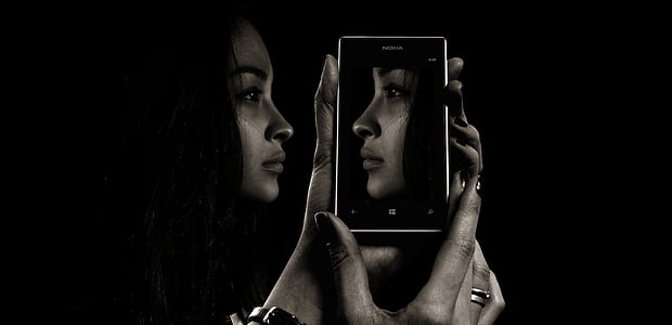 woman holding smartphone with portrait wallpaper