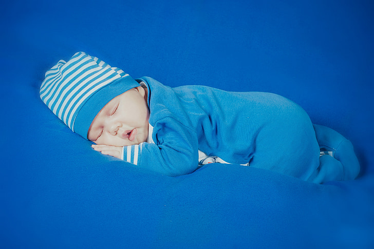baby in blue and white striped footsie sleeping