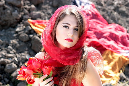woman wearing red scarf holding red tulips