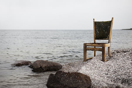 brown wooden armless chair on seashore