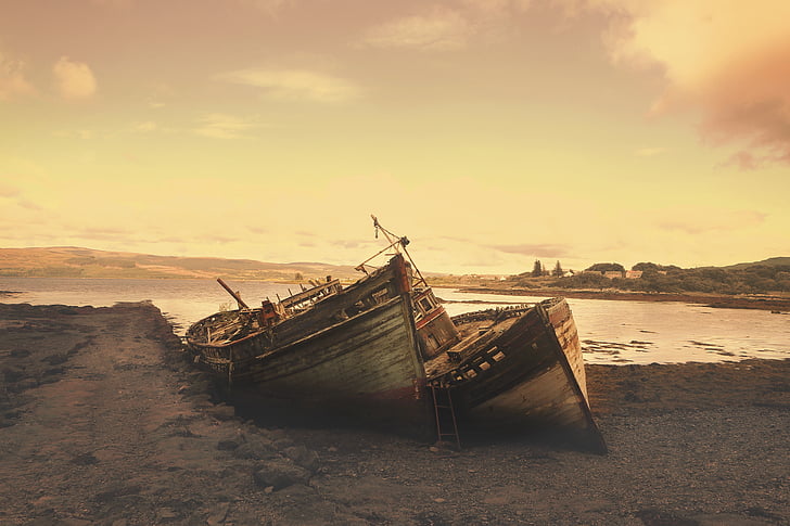 two brown boats on seashore at golden hour