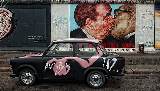 black and pink sedan beside two man kissing wall paint