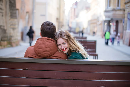 woman smiling beside the man wearing brown hooded jacket