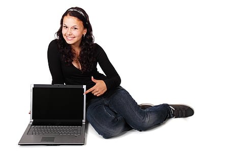 woman sitting on floor beside laptop computer