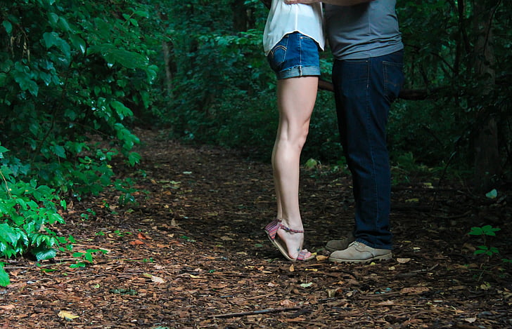 couple standing in the middle of forest during daytime