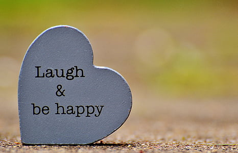 Laugh & be happy text on heart-shaped gray concrete decor