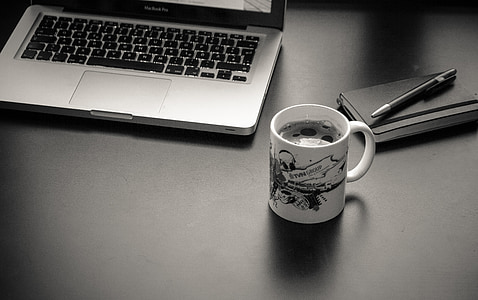 MaCbook Pro beside ceramic mug