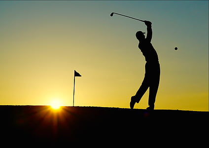 silhouette of a man playing golf
