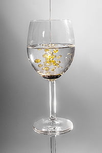 clear wine glass filled with clear and yellow liquid