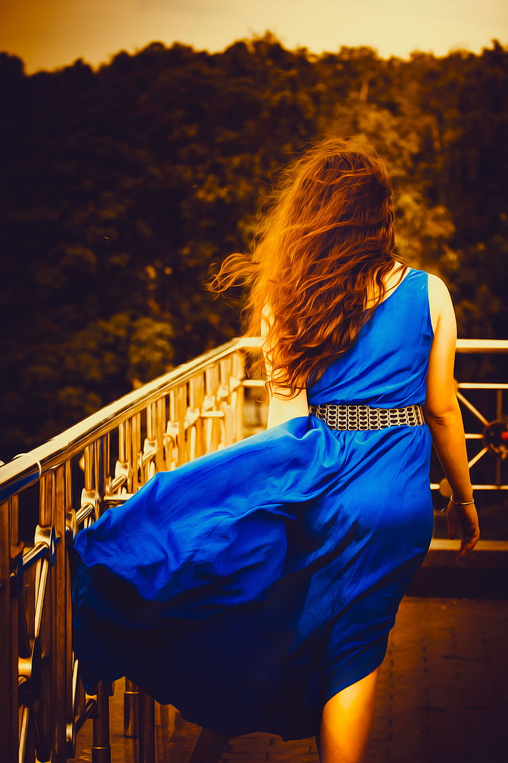 woman wearing blue sleeveless dress
