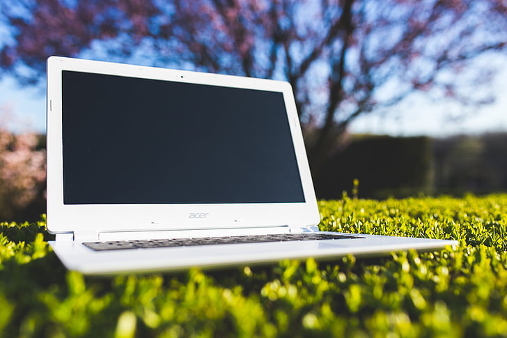white Acer laptop on grass field