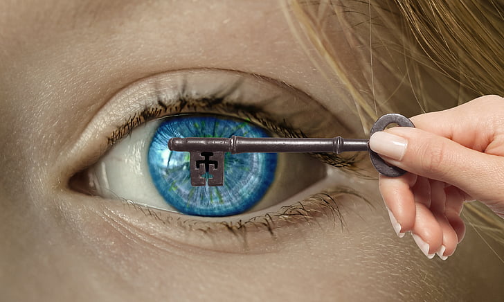 person holding key covering person's left eyeball