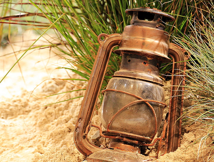 brown gas lantern on sand during daytime