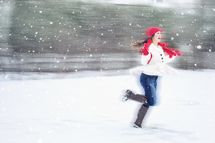 woman in white coat with red scarf with brown boots on snow