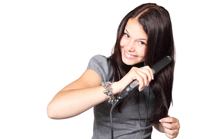 woman holding black hair straightener