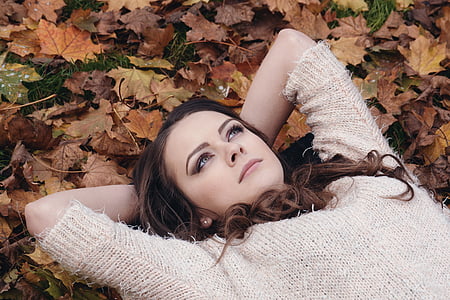 woman laying on dried leaves photo