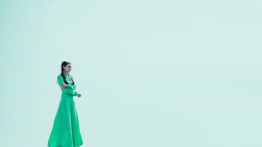 woman wearing green gown standing facing right direction