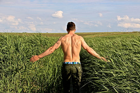 man with brown bottoms in green grass field