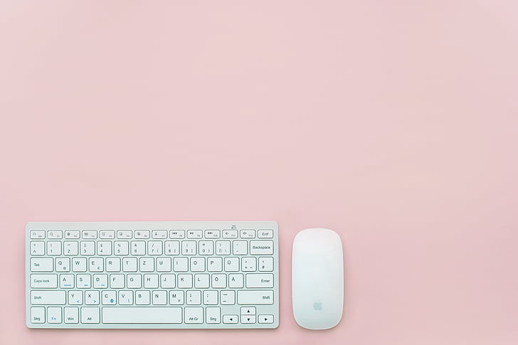 white Apple Magic Mouse and magic keyboard with pink background