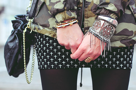 person in green and black camouflage long-sleeved top wearing bracelets and rings