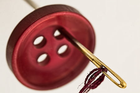 brown needle and red clothes button