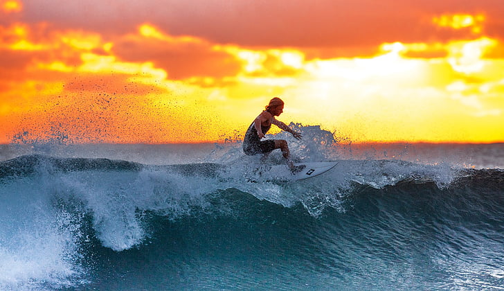 woman surfing during sunset