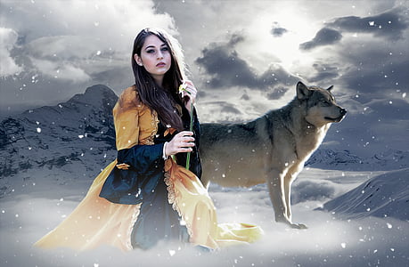 woman sitting near wolf against mountain with snow background