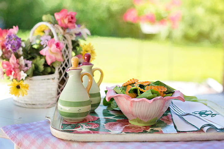 pink bowl filled with salad on tray beside table napkin