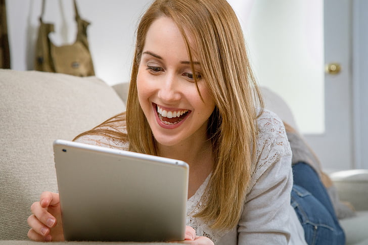 woman holding tablet computer smiling