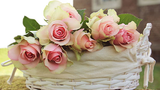 pink and white roses arrange in wicker white basket