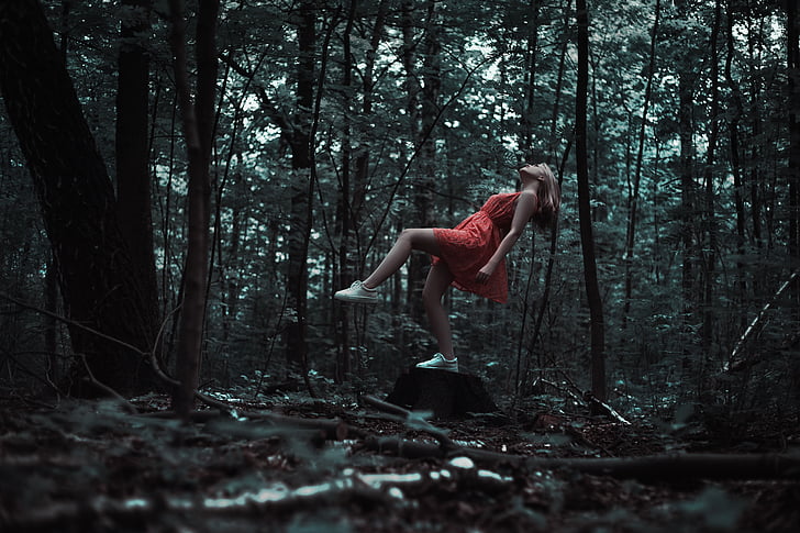 woman wearing red dress in forest