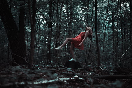 woman wearing red dress in forest