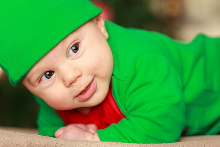 baby wearing green top and hat