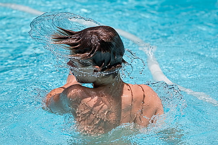 boy with black hair spinning head in pool