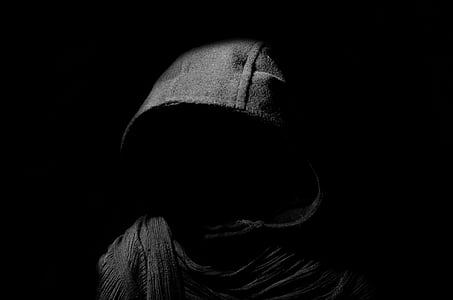 person wearing gray hoodie inside dark room